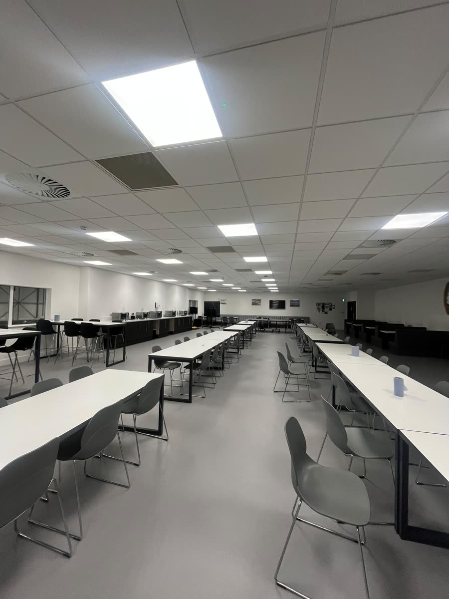 Large open office and dining area with clean desks, chairs and floor